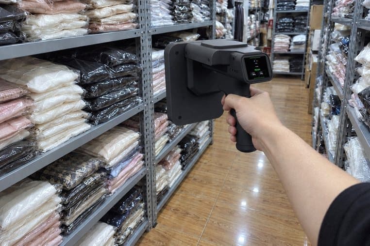 Hình minh hoạ: rà máy quét RFID cầm tay dọc kệ quần áo đóng túi trong kho sau