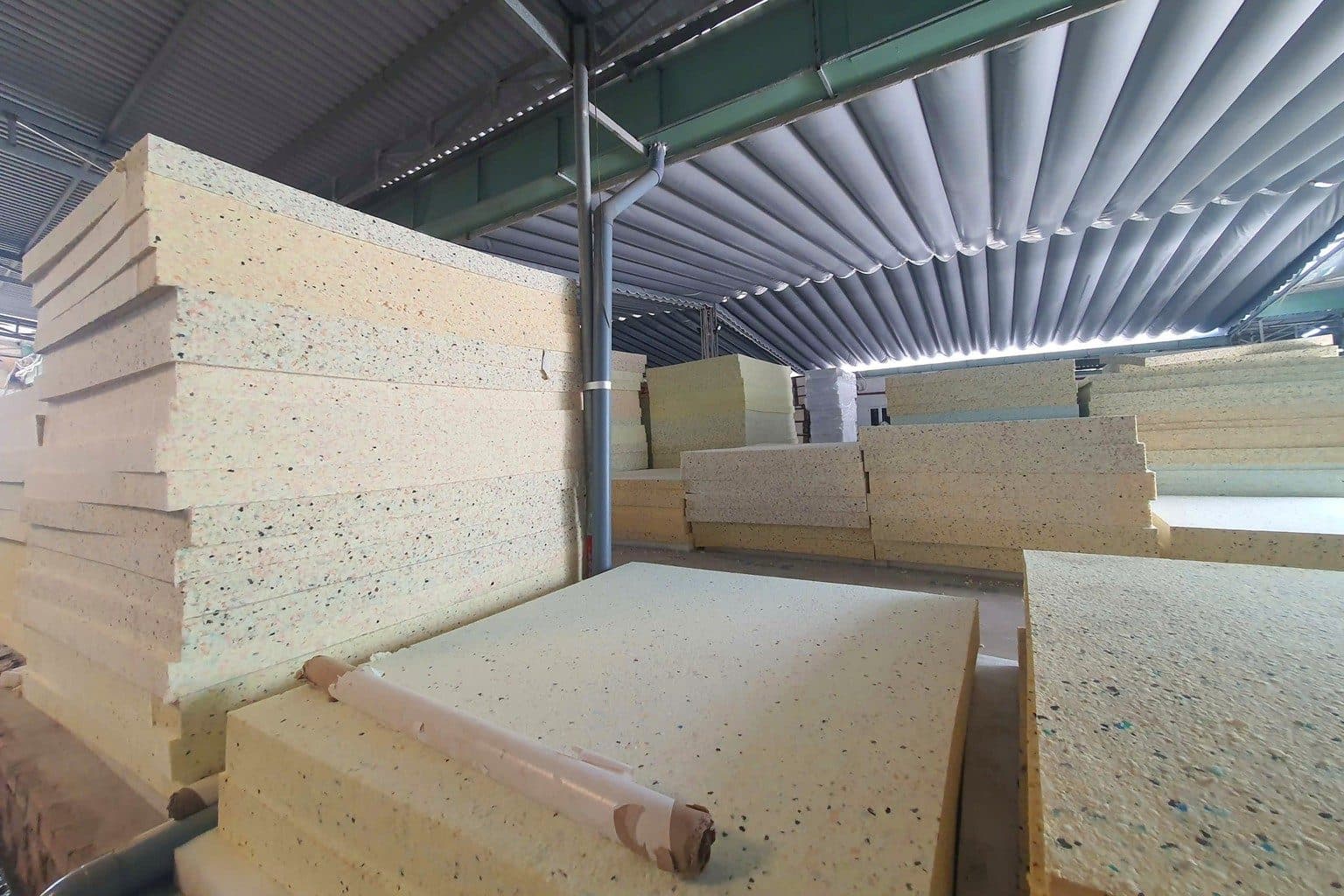 Những chồng tấm mút làm nệm chất cao trong xưởng
