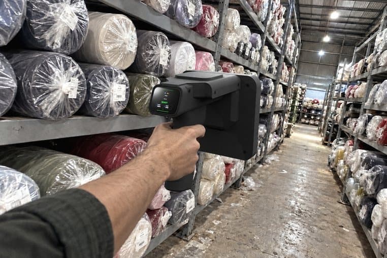 Hình minh hoạ: rà máy quét RFID cầm tay dọc kệ cuộn vải trong lối đi của kho