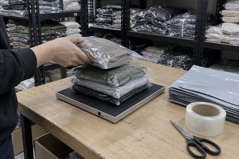 Hình minh hoạ: đặt chồng túi hàng lên đầu đọc RFID để bàn, cạnh túi gói hàng và cuộn băng keo