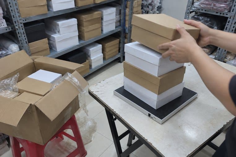 Hình minh hoạ: đặt chồng hộp giày mới về lên đầu đọc RFID để bàn