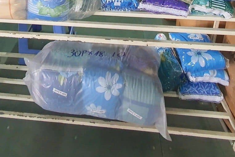 Túi chăn ga trên kệ, dán nhãn giấy ghi kích thước bằng tay