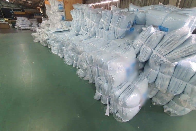 Dãy kiện gối bọc nilon xếp hàng trên sàn kho chờ xuất